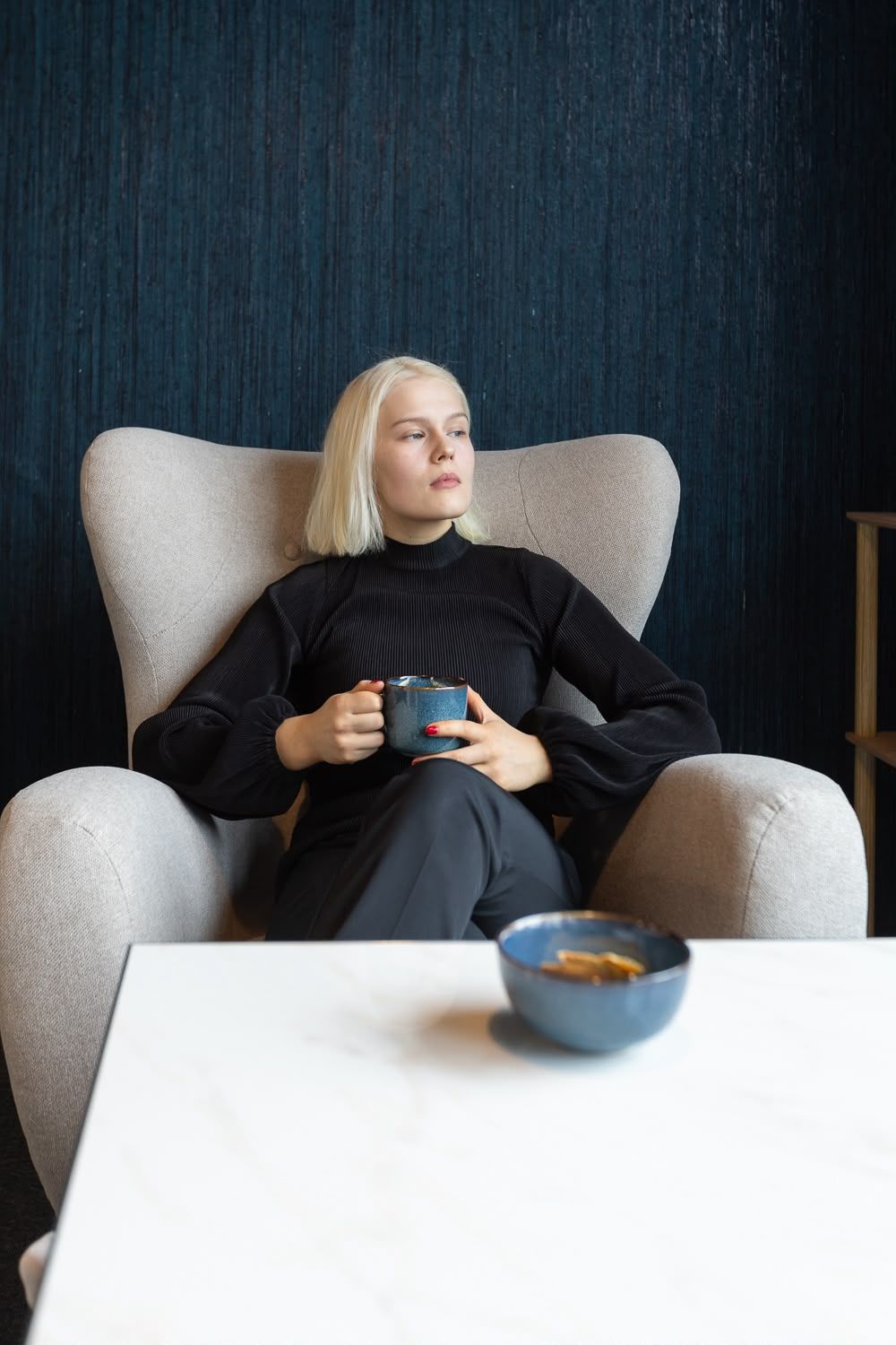 Jenna Palauttamo Floatsin oleskelutilassa kahvikupin kanssa